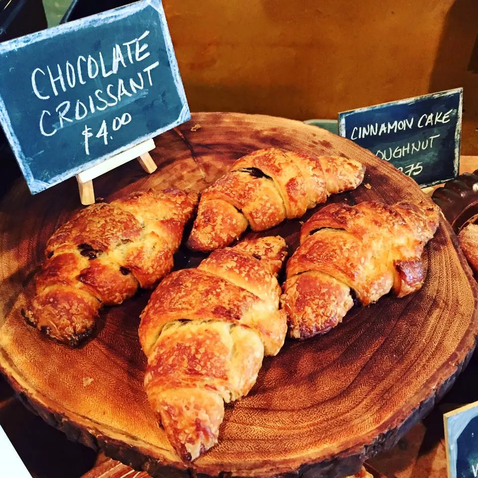 Chocolate croissants cooling on a wooden board