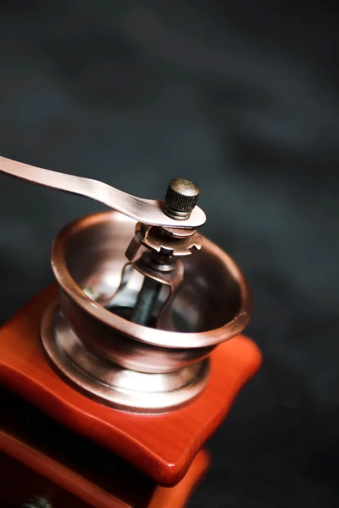 A hand grinder beside freshly ground coffee